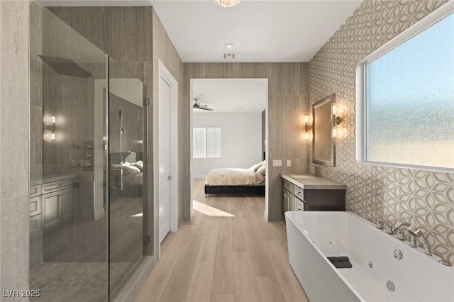 bathroom with shower with separate bathtub, wood-type flooring, vanity, and ceiling fan