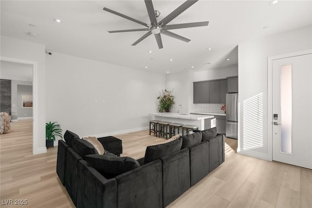 living room with ceiling fan and light wood-type flooring