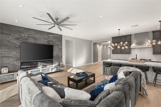 living room with ceiling fan and light hardwood / wood-style floors