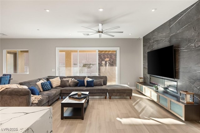 living room with ceiling fan and light wood-type flooring