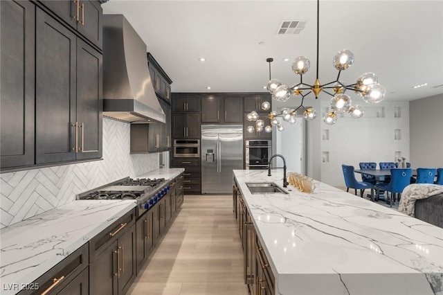 kitchen featuring a spacious island, stainless steel appliances, sink, and extractor fan