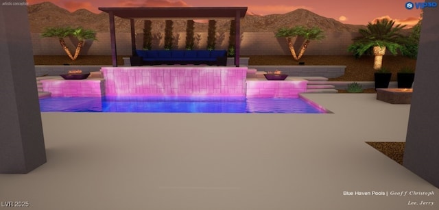 pool at dusk featuring a mountain view and a patio area