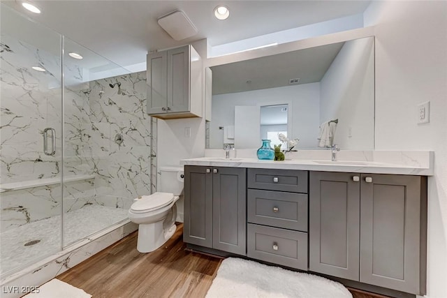 bathroom featuring vanity, hardwood / wood-style flooring, toilet, and walk in shower