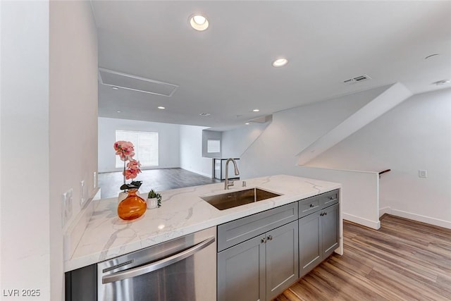 kitchen featuring light stone counters, sink, gray cabinets, and stainless steel dishwasher