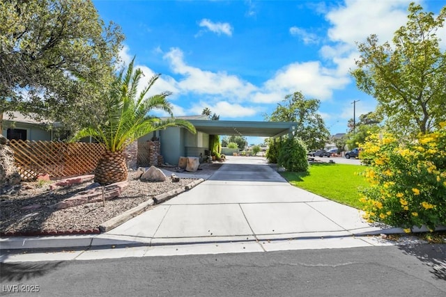 view of front of home with a carport and a front lawn