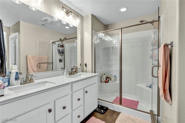 bathroom with an enclosed shower, vanity, and wood-type flooring