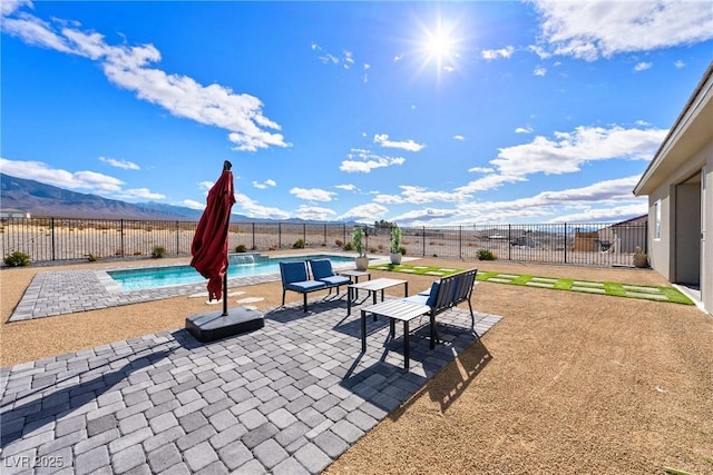 view of patio with a fenced in pool and a mountain view