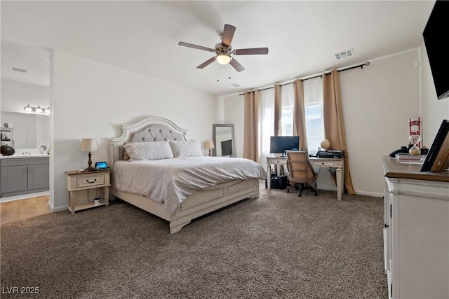 bedroom featuring dark colored carpet, ceiling fan, and ensuite bath