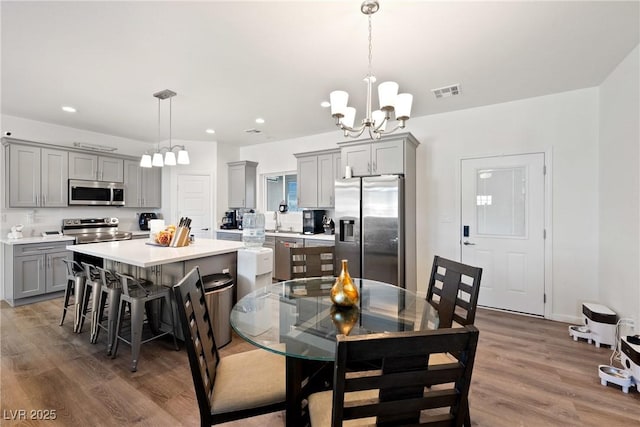 dining space with dark hardwood / wood-style flooring, a notable chandelier, and sink