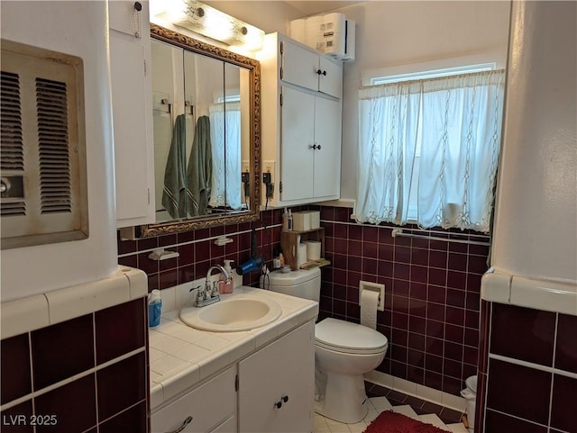 bathroom featuring tile patterned flooring, vanity, tile walls, and toilet