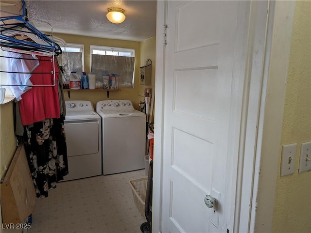 laundry area with washer and dryer and a textured ceiling