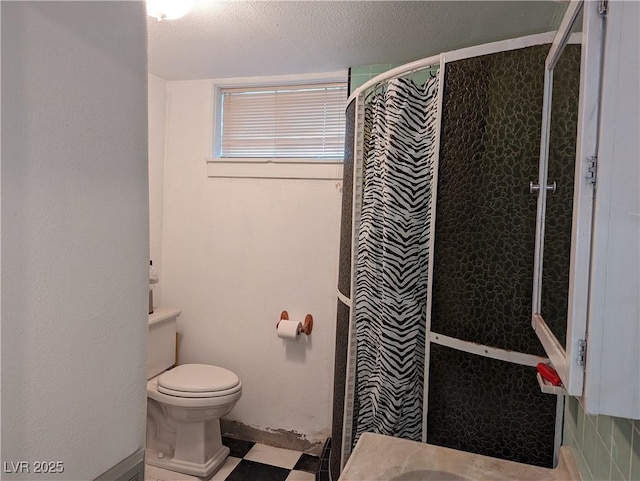 bathroom featuring tiled shower, toilet, and a textured ceiling