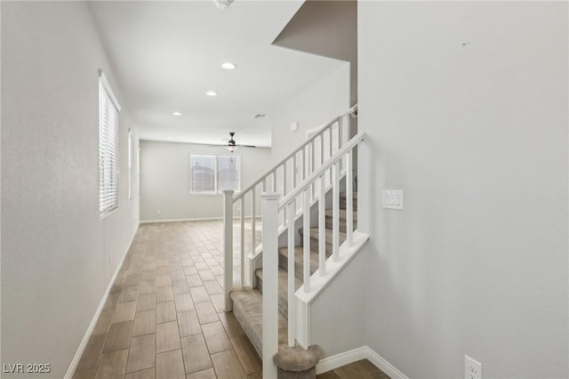 staircase with hardwood / wood-style flooring and ceiling fan