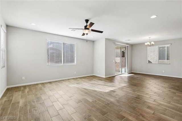 unfurnished living room with hardwood / wood-style flooring and ceiling fan with notable chandelier