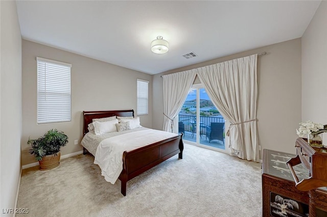 bedroom with access to outside and light colored carpet