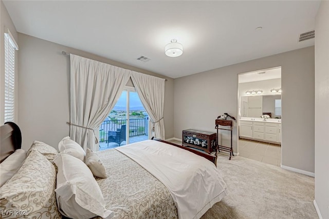 bedroom with access to exterior, ensuite bath, and light colored carpet