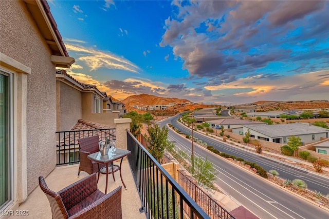 balcony at dusk featuring a mountain view