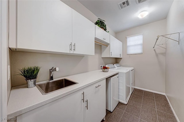 laundry area with cabinets, sink, and washing machine and dryer