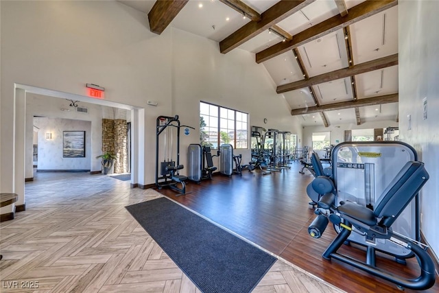 exercise room featuring a towering ceiling and light parquet flooring