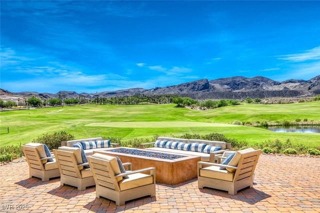 view of patio / terrace featuring a water and mountain view and an outdoor fire pit