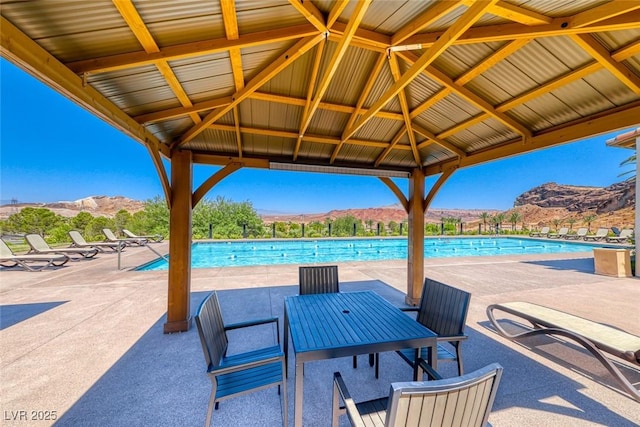 view of patio / terrace with a mountain view, a gazebo, and a community pool