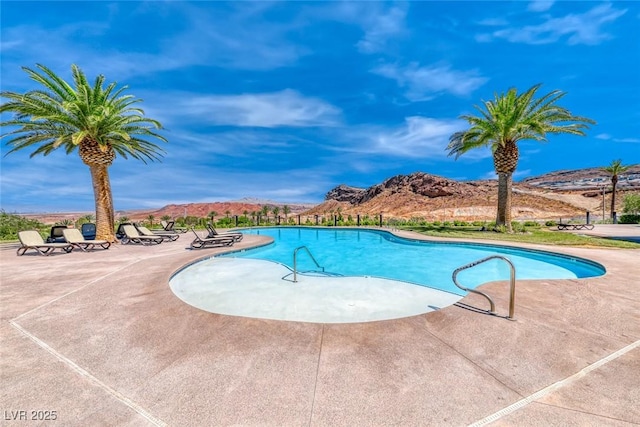 view of swimming pool featuring a patio and a mountain view