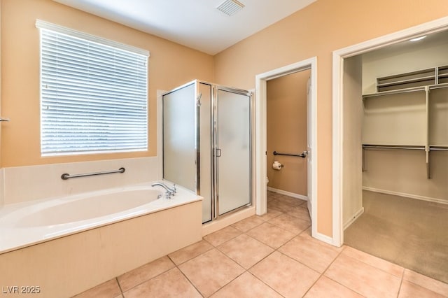 bathroom with tile patterned flooring, visible vents, a spacious closet, and a shower stall