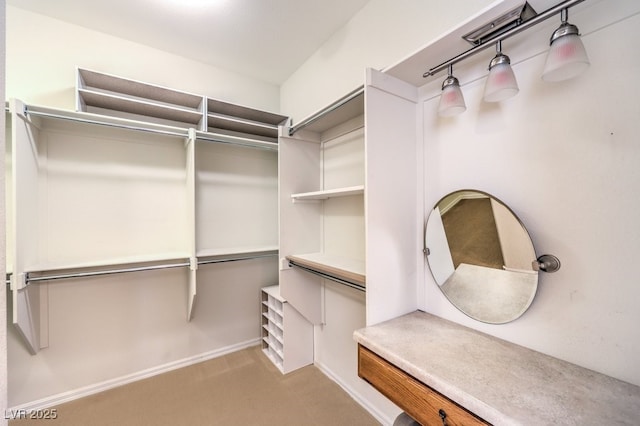 walk in closet with light colored carpet