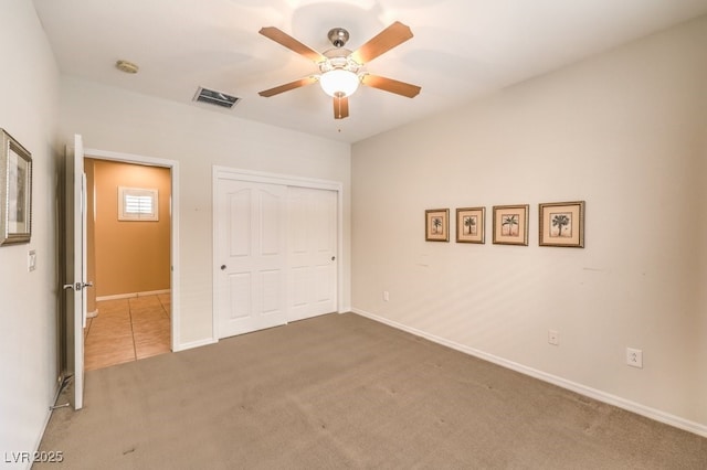 unfurnished bedroom with carpet floors, a closet, visible vents, and baseboards