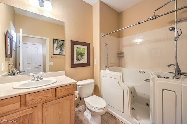 bathroom with toilet, a combined bath / shower with jetted tub, and vanity