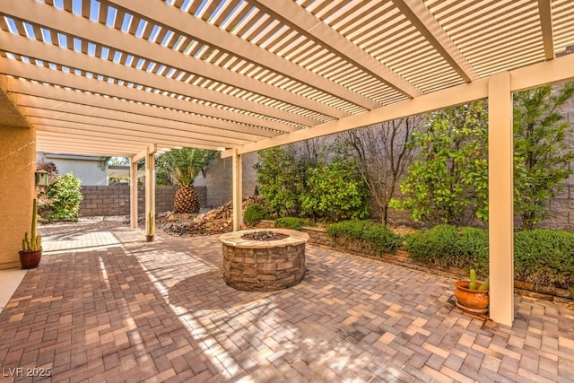 view of patio with fence, a fire pit, and a pergola