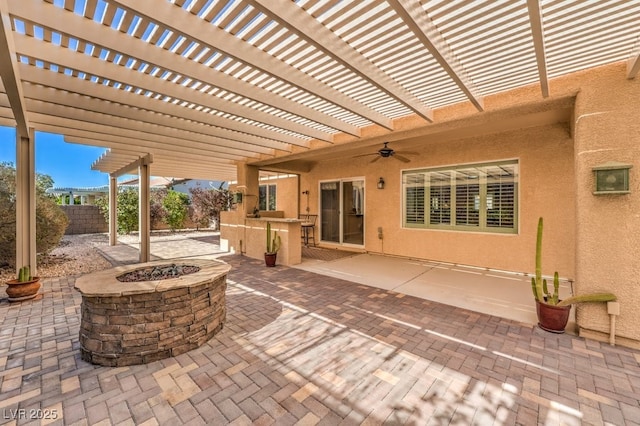 view of patio featuring an outdoor fire pit, fence, a ceiling fan, and a pergola