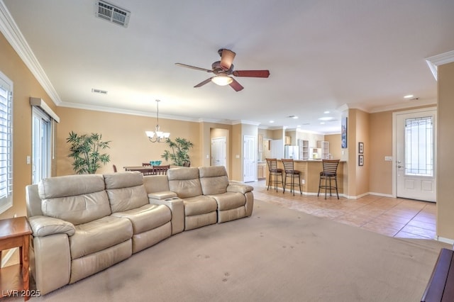 living area featuring light tile patterned floors, ornamental molding, ceiling fan with notable chandelier, and visible vents