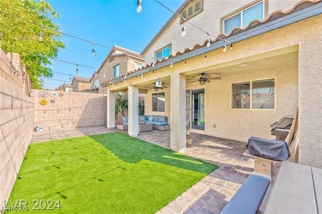 rear view of house with an outdoor hangout area, a patio, ceiling fan, and a lawn