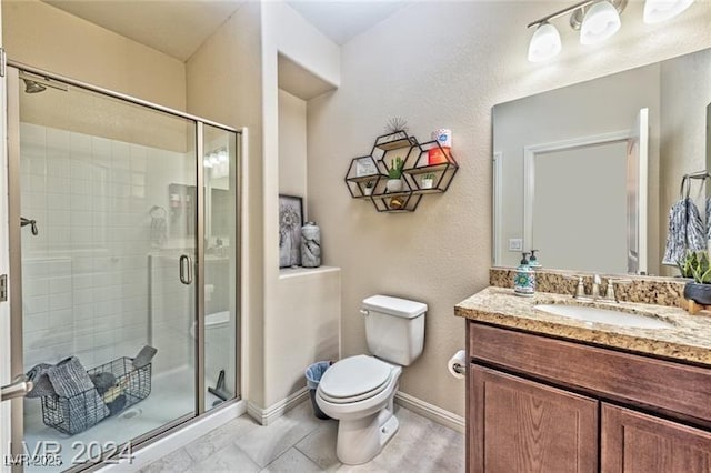 bathroom featuring vanity, tile patterned flooring, toilet, and walk in shower