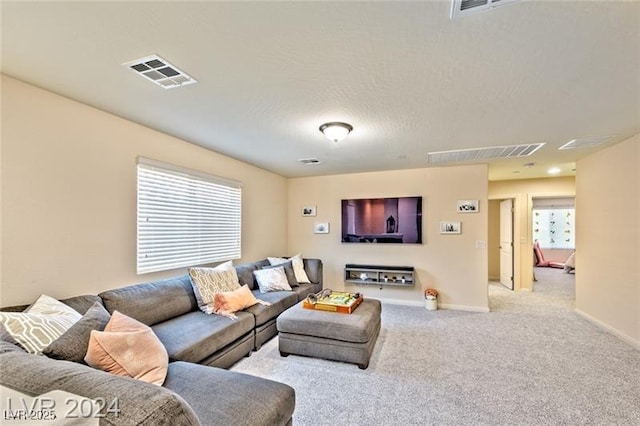 carpeted living room featuring a textured ceiling