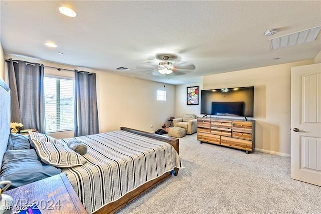 carpeted bedroom featuring multiple windows and ceiling fan