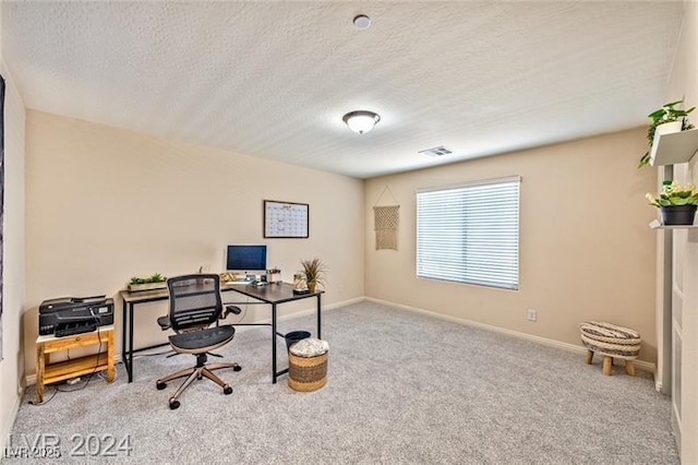 carpeted home office featuring a textured ceiling