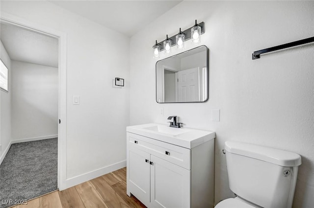 bathroom featuring wood-type flooring, vanity, and toilet