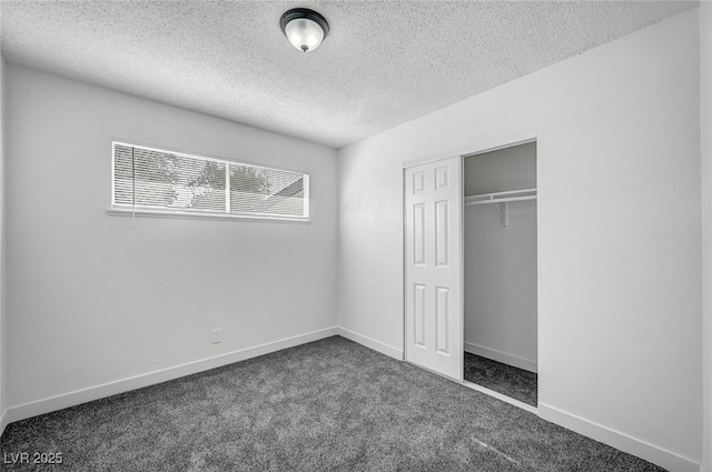 unfurnished bedroom with a closet, a textured ceiling, and dark colored carpet