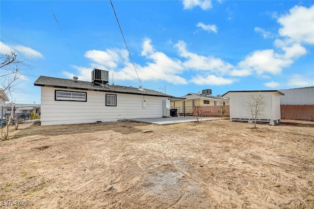 rear view of property with a shed, a patio area, and central air condition unit