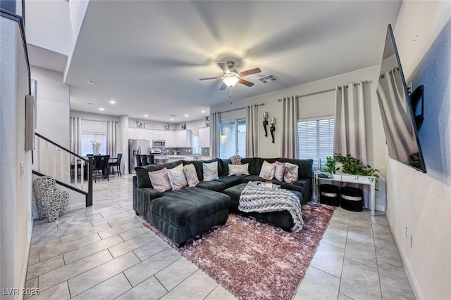 living room featuring ceiling fan, light tile patterned floors, and a wealth of natural light