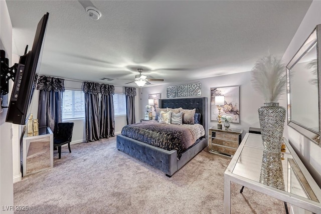 bedroom featuring ceiling fan, light colored carpet, and a textured ceiling