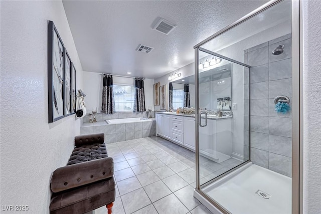 bathroom featuring vanity, separate shower and tub, tile patterned floors, and a textured ceiling