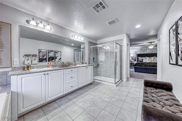 bathroom with vanity, ceiling fan, a shower with door, tile patterned floors, and a textured ceiling