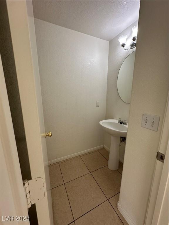 bathroom with tile patterned floors and a textured ceiling