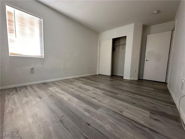 unfurnished bedroom with hardwood / wood-style floors and a closet