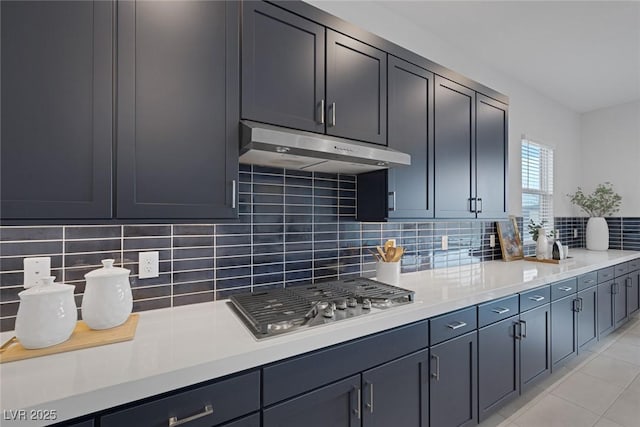 kitchen featuring backsplash, light tile patterned floors, and stainless steel gas cooktop