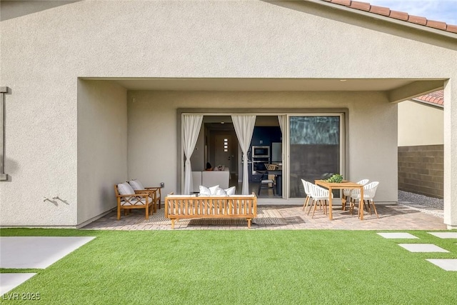 back of house featuring an outdoor living space, a lawn, and a patio