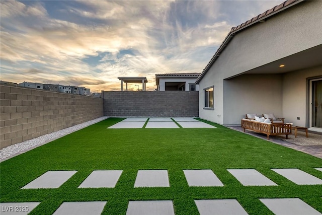 yard at dusk featuring outdoor lounge area and a patio area